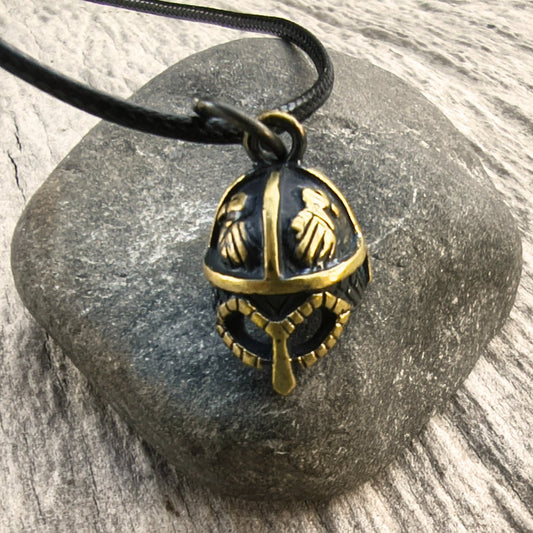 Hand-cast brass Viking helmet pendant featuring two ravens, 18 × 12 mm, with adjustable cord, inspired by Norse mythology.