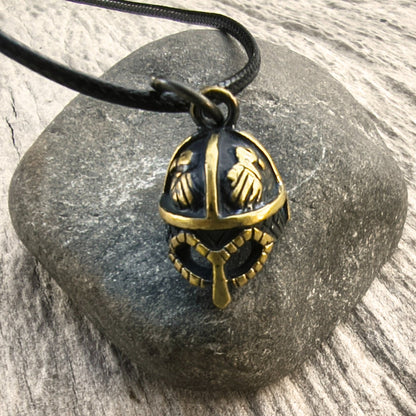 Hand-cast brass Viking helmet pendant featuring two ravens, 18 × 12 mm, with adjustable cord, inspired by Norse mythology.