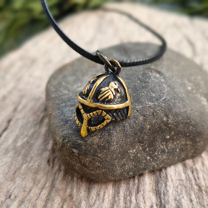 Hand-cast brass Viking helmet pendant featuring two ravens, 18 × 12 mm, with adjustable cord, inspired by Norse mythology.