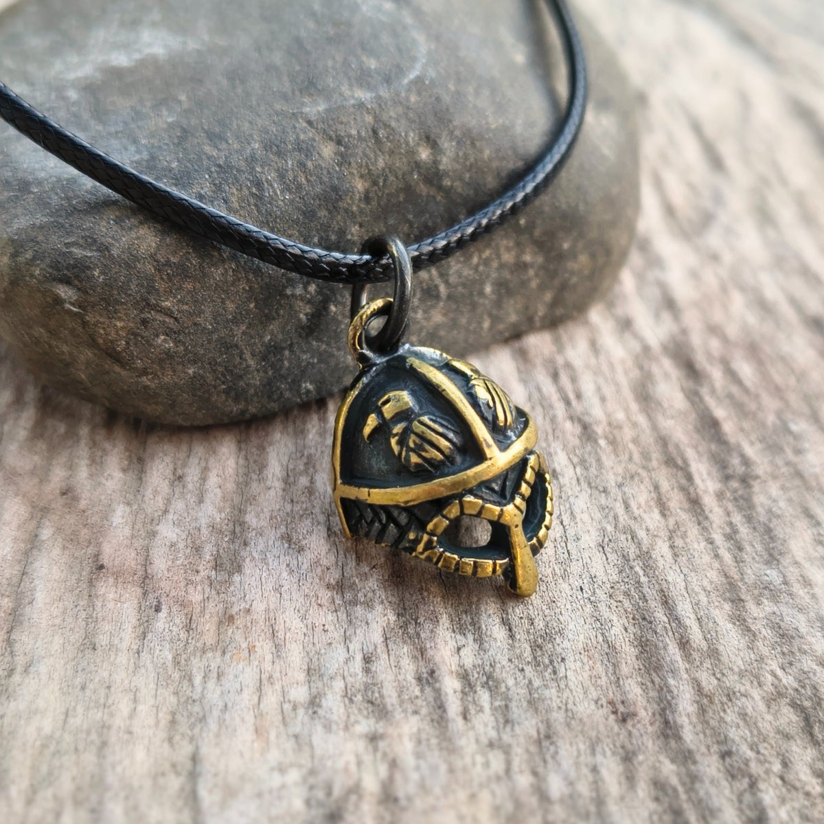 Hand-cast brass Viking helmet pendant featuring two ravens, 18 × 12 mm, with adjustable cord, inspired by Norse mythology.