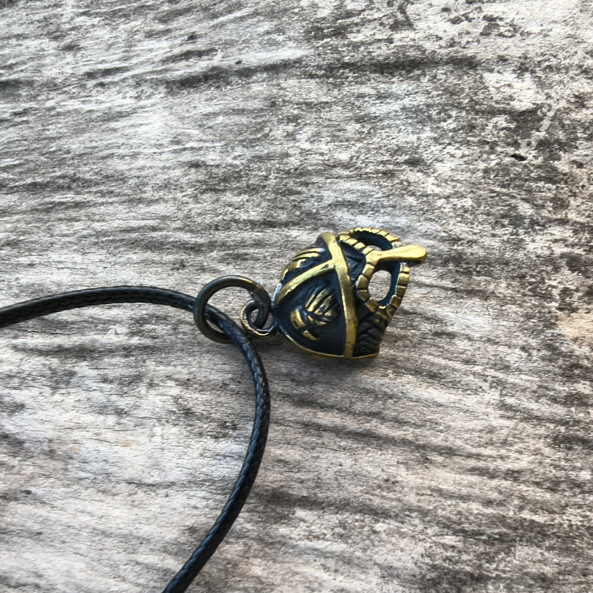 Hand-cast brass Viking helmet pendant featuring two ravens, 18 × 12 mm, with adjustable cord, inspired by Norse mythology.