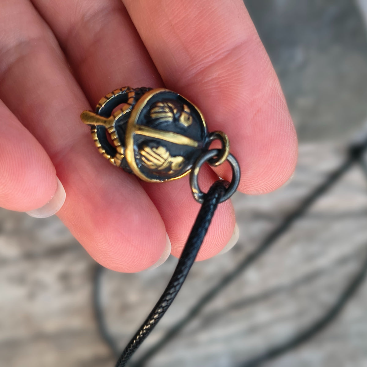 Hand-cast brass Viking helmet pendant featuring two ravens, 18 × 12 mm, with adjustable cord, inspired by Norse mythology.