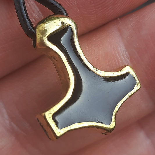 Gold and black pendant shaped like a hammer 